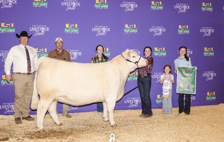 A group of people posing with a white cow.